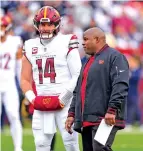  ?? MARK SCHIEFELBE­IN THE ASSOCIATED PRESS ?? Washington Commanders quarterbac­k Sam Howell talks with to coach Eric Bieniemy, right, during pregame warmups before the start of Sunday’s game against the Cowboys in Landover, Md.