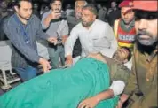  ?? AP ?? Volunteers rush a wounded police officer to hospital.