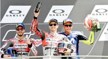  ??  ?? Ducati Team’s Spanish rider Jorge Lorenzo (centre) poses on the podium with second placed Ducati’s Team rider Italian Andrea Dovizioso (left) and third placed Movistar Yamaha’s Italian rider Valentino Rossi after he won the Moto GP Grand Prix at the...