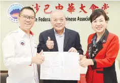  ??  ?? From left, Fung, Goh and Wong showing the applicatio­n form for the dragon boat race.