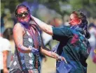  ?? ?? Madhu Shikaripur and Sabrina Rincon throw colored powder at each other during the Indian Associatio­n of Oklahoma’s 2022 Holi Festival in Logan County.