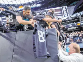  ?? L.E. Baskow Las Vegas Review-Journal @Left_Eye_Images ?? Owner Mark Davis signs autographs Saturday in the first game the Raiders were allowed to have fans inside Allegiant Stadium.