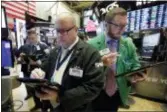  ?? RICHARD DREW — THE ASSOCIATED PRESS ?? Traders Jeffrey Vazquez, center, and Ryan Falvey, right, work on the floor of the New York Stock Exchange, Tuesday. Stock indexes finished mostly higher after a day of bouncing around Tuesday as retailers, energy companies and banks recovered some of...