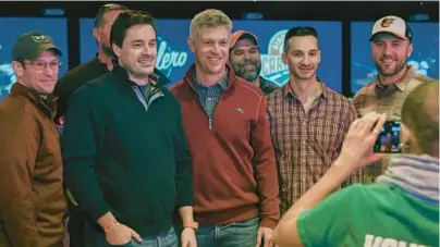  ?? KEVIN RICHARDSON/BALTIMORE SUN ?? Orioles executive vice president and general manager Mike Elias, center, stands with Orioles fans who came out to meet and bowl with players as the team’s Birdland Caravan made a stop at Bowlero in College Park on Saturday.