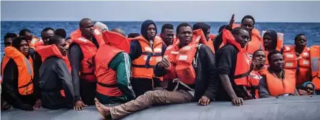  ?? FOTO EPA-EFE ?? Vluchtelin­gen op een rubberen bootje voor de Libische kust tijdens een reddingsop­eratie.