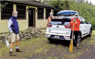  ?? PAT NICKLIN PHOTOS ?? TOP: After an eventful river trip, the canoeists are greeted by the author at the Rappahanno­ck takeout. ABOVE: From left, Jim, the author and Ann are ready to transport boats to their Rappahanno­ck put-in for a pandemic paddle.