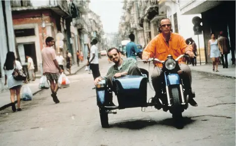  ??  ?? Musicians Joachim Cooder, left, and his dad Ry take a ride in Havana during a break from recording the 1997 Cuban album Buena Vista Social Club.