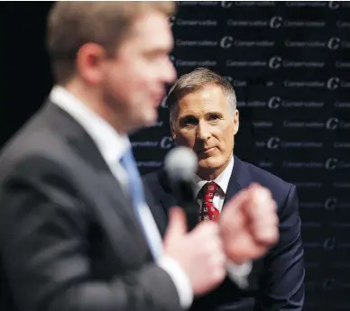  ?? IAN KUCERAK / POSTMEDIA NEWS FILES ?? Maxime Bernier listens to Andrew Scheer during the Conservati­ve leadership debate in February 2017. Bernier’s accusation that Scheer signed up thousands of “fake” voters caused blowback within the party caucus this week.