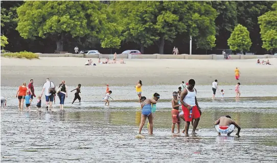  ?? STAFF PHOTOSS, TOP, BY STUART CAHILL; ABOVE AND TOP RIGHT, BY PATRICK WHITTEMORE ?? WADING RIGHT IN: Visitors enjoy Carson Beach at low tide on Saturday. Clean water has led to more enjoyment of the great outdoors.