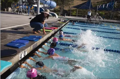  ?? PHOTOS BY ANDREW FOULK ?? Casey Winger, a swim instructor, shows students how to kick at the Community Recreation Center pool in Temecula on May 5. Swimmers and parents of the Temecula Swim Club, citing lack of space, are appealing for the city to build an Olympic-sized 50-meter pool.
