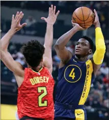  ?? Michael Conroy / AP ?? Indiana’s Victor Oladipo (right) shoots over Atlanta’s Tyler Dorsey during the first half of Friday’s game in Indianapol­is.