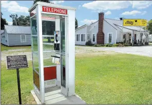  ?? NWA Democrat-Gazette/ANDY SHUPE ?? A 1959 telephone booth stands Friday along Douglas Street in Prairie Grove beside a sign that explains that the booth is on the National Register of Historic Places.