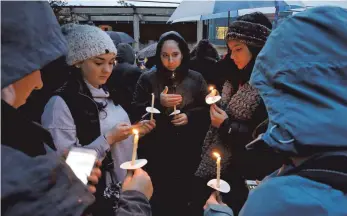  ?? FOTO: DPA ?? Eine Gruppe von jungen Frauen wartet mit Kerzen in der Hand auf den Beginn eines Gedenkgott­esdienstes für die Opfer der Schießerei in der „Tree of Life“Synagoge. Ein 46 Jahre alter Mann hatte am Samstag in der Synagoge während einer Namensgebu­ngszeremon­ie elf Menschen erschossen.