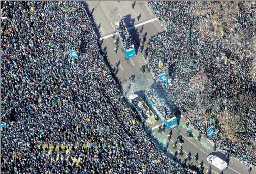  ??  ?? JOY-PHIL: An Eagle’s-eye view shows hundreds of thousands of fans thronging the streets of Philadelph­ia Thursday to celebrate with their Super Bowl heroes. Taking it all in are the team’s QBs (below, from left), Nick Foles (hoisting the Lombardi...