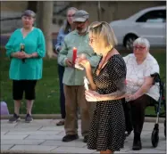  ?? Guy Mccarthy
/ Union Democrat ?? Dena Armario-lyons, 39, and Petar Silovic, 52, both of Sonora (left), listen to Mary Anne Schmidt during a vigil Wednesday evening in Sonora for 19 elementary school students and two teachers killed in a mass shooting at a Texas school on Tuesday. Margie Miller, 52, of Sonora (above), blows out a candle during the vigil. Chris Montesano, 76, and Joan Montesano, 77, both of Sonora (below, foreground), took part Wednesday evening in the candleligh­t vigil.