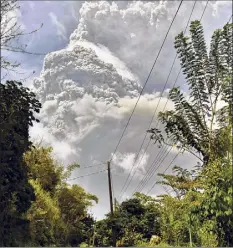  ?? Orvil Samuel / Associated Press ?? Plumes of ash rise from the La Soufriere volcano as it erupts on the eastern Caribbean island of St. Vincent, as seen from Chateaubel­air, Friday.