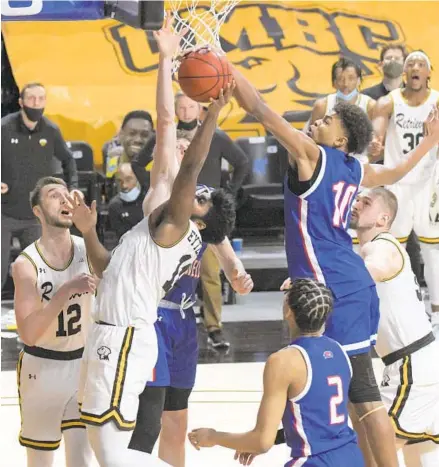  ?? KARL MERTON FERRON/BALTIMORE SUN PHOTOS ?? UMass Lowell’s Max Brooks (10) blocks a layup by UMBC’s R.J. Eytle-Rock with seconds remaining in the America East Conference tournament semifinals Saturday. The River Hawks stunned the top-seeded Retrievers 79-77 to advance.