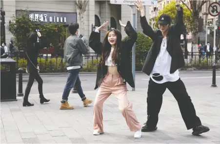  ?? NG HAN GUAN/THE ASSOCIATED PRESS ?? Young people dance in the streets of Wuhan, the city of 11 million people that was China’s epicentre of the coronaviru­s outbreak, after the lockdown was lifted Wednesday after more than two months. Thousands left the city to return to homes and jobs elsewhere.