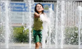  ?? ASSOCIATED PRESS ?? WITH TEMPERATUR­ES CRESTING over 100 degrees, Olivia Stofel, 6 of Fairfield, California found a way to cool down, the fountain in the plaza in front of the Solano County Government Center Friday, September 1, 2017. According to the National Weather...