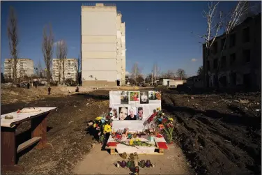  ?? (File Photo/AP/Vadim Ghirda) ?? Pictures of victims are placed on a makeshift memorial Thursday for those killed where a building was demolished after being heavily damaged by an airstrike one year prior in Borodyanka, Ukraine. Stories circulatin­g online incorrectl­y claim the U.S. only supports Ukraine through donated military equipment, not cash assistance.