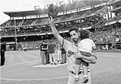  ?? BRAD MILLS/USA TODAY SPORTS ?? New Brewers pitcher Gio Gonzalez, holding his son, Enzo, salutes the Nationals crowd after Washington traded him on Aug. 31.