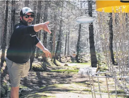  ?? DANIEL BROWN/LOCAL JOURNALISM REPORTER ?? Jacob Smith, owner of Island Disc Golf Company, tosses a disc into a target at Hillcrest Farm Disc Golf in Bonshaw on May 20.