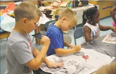  ?? SUBMITTED PHOTOS ?? Walter J. Mitchell Elementary School third graders Nick Mudd, left, and Mark Scopp work on their arts and crafts projects with Kai Spraggins, a second grader at J.C. Parks Elementary School, during summer camp at Henry E. Lackey High School.