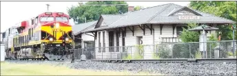  ?? Westside Eagle Observer file photo/MIKE ECKELS ?? A Kansas City Southern freight train passes the century-old Decatur Depot Aug. 5, 2016, on its way south. The depot and storage building are slated to receive an exterior make-over by November of 2019.