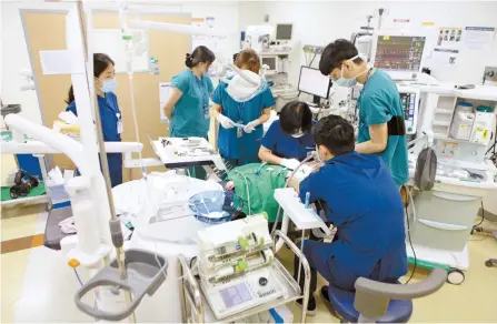  ?? Courtesy of SNUDH ?? Doctors of Seoul National University Dental Hospital (SNUDH) perform dental surgery on a patient with a disability at the school’s National Dental Care Center for Persons with Special Needs.