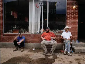  ?? ?? Cody Hawkins (from left), Joe Kincer and Charles Hawkins take a break Friday after pulling up floorboard­s to rebuild the Curiosity Shop in Fleming-Neon.