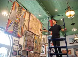  ?? File photo by Kelsi Brinkmeyer ?? ■ Artist Christophe­r Bachers adjusts one of his works hanging in the 1894 Gallery.