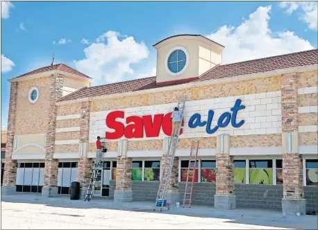  ?? [SARAH PHIPPS/ THE OKLAHOMAN] ?? Workers clean the signage Wednesday on the former Save-A-Lot building at 1124 NE 36 in Oklahoma City.