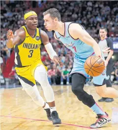  ??  ?? HEAT HERO: Miami’s Goran Dragic, right, drives against Indiana’s Aaron Holiday.