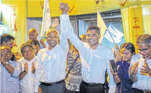  ?? REUTERS ?? President-elect Ibrahim Mohamed Solih, third left, and his running mate Faisal Naseem, third right, celebrate their election victory at their campaign headquarte­rs.