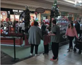  ?? CHAD FELTON — THE NEWS-HERALD ?? Visitors await their turns to pose with Santa at the Great Lakes Mall on Dec. 2 during Sensitive Santa, a 90-minute private photo opportunit­y event held by the mall in partnershi­p with Autism Speaks. Altogether, about 45 families attended, nearly reaching capacity.