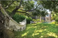  ?? The Associated Press ?? OUTDOOR SPACES: This photo provided by Rottet Studio shows a backyard designed by architect and interior designer Lauren Rottet in Montauk, N.Y. Adding a cozy hammock as Rottet did in this backyard, brings beauty and comfort and can be especially useful if you’re staying home for much of this summer.