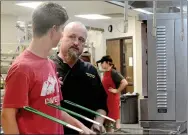  ?? Hunter McFerrin/Herald-Leader ?? Camp Siloam Executive Chef Marty Hayes (right) gives advice to one of his cooks, Garrett Martin, (left) while in the kitchen on Saturday morning.