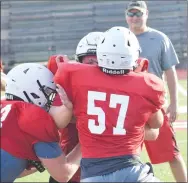  ?? RICK PECK/SPECIAL TO MCDONALD COUNTY PRESS ?? Levi Neale takes on a double-team block by Garrett Gricks (left) and Danny Grider (57) during a drill during last week’s team camp at MCHS.