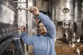  ?? At her Winery in Stellenbos­ch, South ?? Stevens pours wine to taste from one the wine tanks Africa.