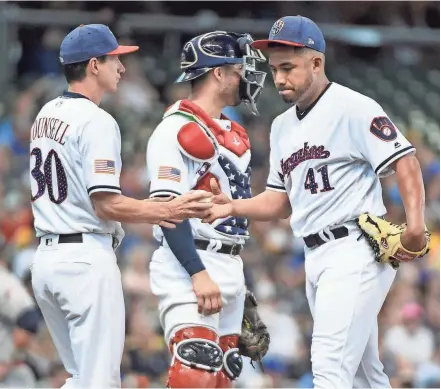  ?? BENNY SIEU / USA TODAY SPORTS ?? Brewers pitcher Junior Guerra hands the ball to manager Craig Counsell during a pitching change in the fifth inning on Sunday.