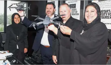  ??  ?? (From right) Fajura, Strat Aero Plc chief operating officer Iain McLure, Wharry and Limkokwing University of Creative Technology Internatio­nal Academic Compliance Unit associate director Noor Nasriyah Osman holding onto drones after announcing the...