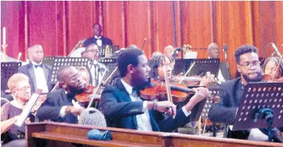  ?? PHOTOS BY MICHAEL RECKORD ?? Members of the string section of the Philharmon­ic Orchestra of Jamaica playing last Saturday evening.