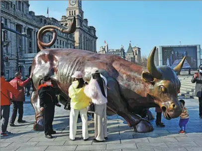  ?? PROVIDED TO CHINA DAILY ?? Visitors touch a bull sculpture in hopes of a better market during the Spring Festival holiday in Shanghai on Feb 16.