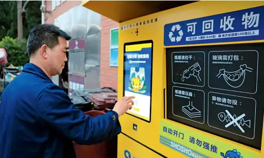  ??  ?? Le 18 mars 2019, un habitant de Shanghai utilise une machine de tri et de recyclage intelligen­te.