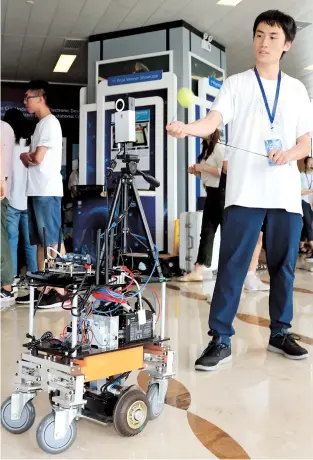  ??  ?? One of three students from Shanghai Jiao Tong University who developed “Robot Safe Eye” — a new approach to robot safety — shows how it works yesterday at the 2018 Intel Cup Undergradu­ate Electronic Design Contest and Embedded System Design Invitation­al Contest. — Xinhua