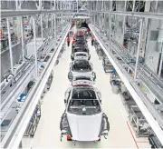  ??  ?? Shells of Porsche Taycan fullelectr­ic sports cars are lined up at the production site of the German car manufactur­er in Stuttgart on May 12 as the production was re-started.