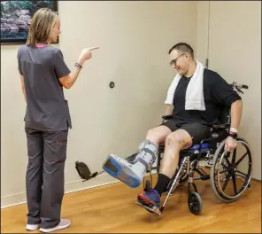  ?? Arkansas Democrat-Gazette/JOHN SYKES JR. ?? Physical therapist Meredith McKelvy gives instructio­n Wednesday to Paul Sanchez, 22, at the Baptist Health Rehabilita­tion Institute in Little Rock. Sanchez, an emergency medical technician, was injured when his ambulance was struck head-on earlier this month on Interstate 40.