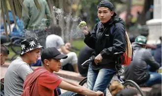  ?? Fernando Vergara - 30.jan.2017/Associated Press ?? Jovens fumam maconha em Bogotá em protesto contra multa a usuários de droga