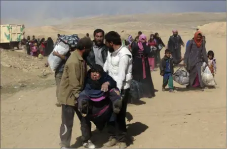  ?? KHALID MOHAMMED — THE ASSOCIATED PRESS ?? Tired displaced Iraqis flee their homes due to fighting between Iraqi security forces and Islamic State militants, on the western side of Mosul, Iraq, Sunday, Feb. 26.