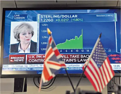  ??  ?? The shape of things to come: Theresa May outlines her plans for Brexit in January, with sterling’s value monitored against the US dollar on a trading floor in London